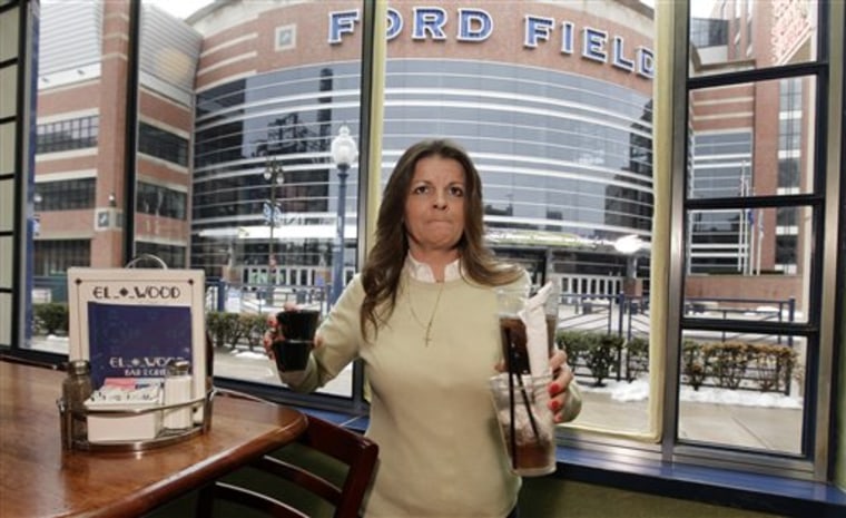 Elwood Bar & Grill manager Liz Markle clears a table with a view of Ford Field in Detroit, home to NFL football's Detroit Lions. 